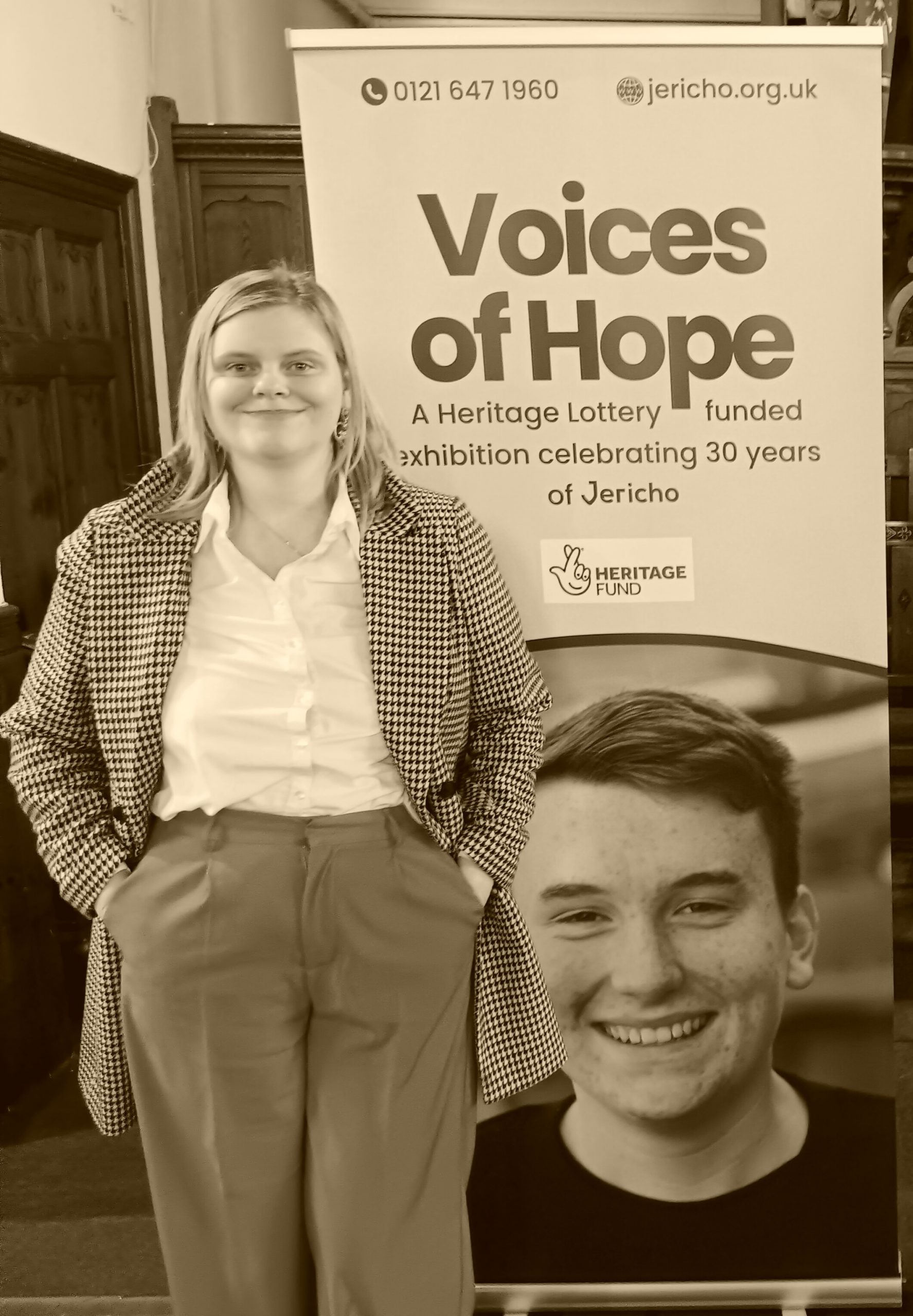 LJR standing next to a poster for Voices of Hope
